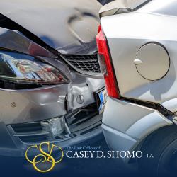 A close-up of a silver car rear-ending a white car in Palm Beach Gardens, FL