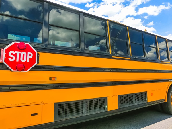 A yellow school bus stopped on a road in Florida with a blue sky and clouds in the background. (218157596)