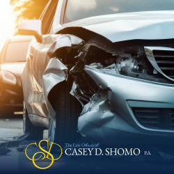 The crushed front end of a heavily damaged car at the scene of a car accident
